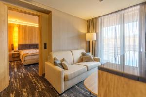 a living room with a couch and a bedroom at Hotel Hills in Stará Lesná