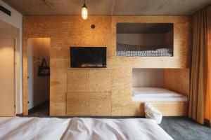 a bedroom with a bed and a television at Superbude Wien Prater in Vienna