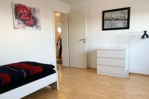 a bedroom with a bed and a dresser and a door at Ruhig gelegene Ferienwohnung mit WLAN in Olpe