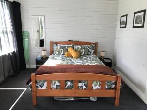 a bedroom with a wooden bed in a room at Stump Cottage in Lumsden