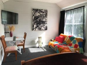 1 dormitorio con cama, escritorio y ventana en Stump Cottage en Lumsden