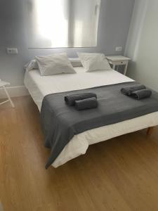 ein großes Bett mit zwei Kissen darüber in der Unterkunft Hostel Once Nudos in Luanco
