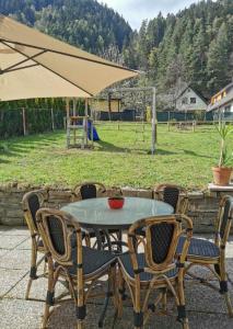 a table and chairs with an umbrella and a field at Villa Kärnten Radenthein in Radenthein