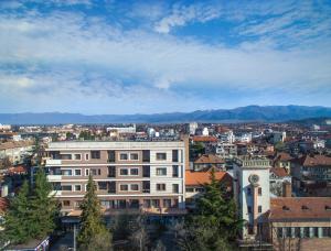 una ciudad con un edificio y montañas en el fondo en Boutique Apartments - Sevtopolis, en Kazanlak