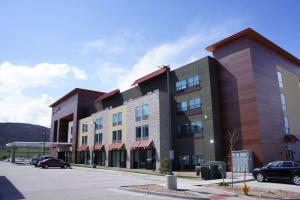 a building with cars parked in a parking lot at La Quinta Inn & Suites by Wyndham Littleton-Red Rocks in Littleton