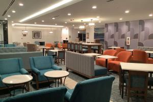 a waiting room with chairs and tables and chairs at La Quinta Inn & Suites by Wyndham Littleton-Red Rocks in Littleton