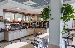 un restaurant avec des tables, des chaises et un comptoir dans l'établissement Ace Hotel Bourges, à Bourges