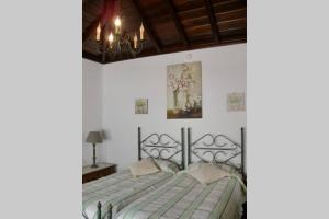 a bedroom with a bed and a chandelier at CASAS COREA in Puntagorda +38 photos