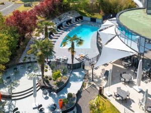 an overhead view of a swimming pool with palm trees at Novotel Poitiers Site du Futuroscope in Chasseneuil-du-Poitou