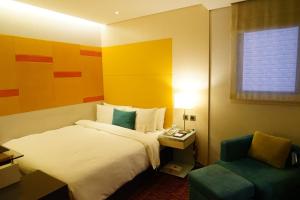 um quarto de hotel com uma cama e uma cadeira em Beauty Hotels - Beautique Hotel em Taipei