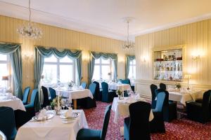 a dining room with tables and chairs and windows at Ringhotel Schloss Tangermünde in Tangermünde