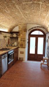 duża kuchnia z kamienną ścianą i drzwiami w obiekcie Zaccheo 9 w mieście Pitigliano