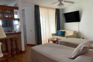 a hotel room with two beds and a couch at Apartamento frente al mar! in Playa de las Americas