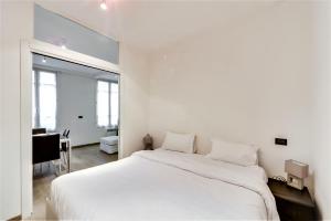 a white bedroom with a large bed and a desk at Marais Saint Paul ID 238 in Paris