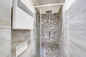 a shower with a glass door in a bathroom at Marais Saint Paul ID 238 in Paris
