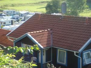 een huis met een rood dak en een parkeerplaats bij Skotteksgården Cottages in Ulricehamn