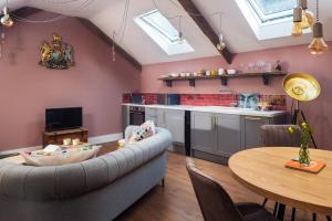 een woonkamer met een bank en een tafel bij The Duchy Barn at Tregoose Old Mill in Newquay