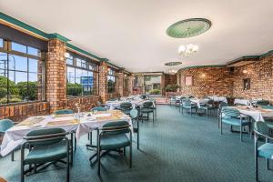 Comfort Inn Glenfield في توومبا: مطعم فيه طاولات وكراسي في الغرفة