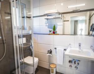 a bathroom with a toilet sink and a shower at Self Service Hotel Kernhof Langstrasse in Zürich
