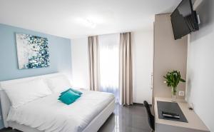 um quarto com uma cama branca e uma almofada azul em Self Service Hotel Kernhof Langstrasse em Zürich