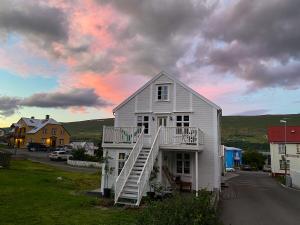 Una casa blanca con escaleras al costado. en Old Town Luxury Apartment Akureyri, en Akureyri