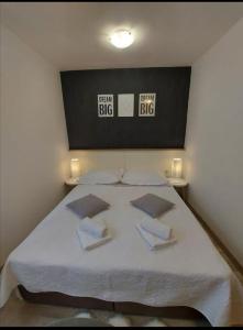 a bedroom with a large bed with three pillows at Palace Stafileo in Trogir