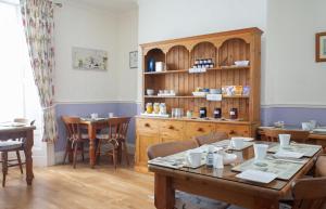 a room with a table and chairs and a shelf at The Parks Guest House in Minehead