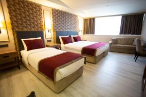 um quarto de hotel com duas camas e um sofá em Beşiktaş Serenity Hotel em Istambul