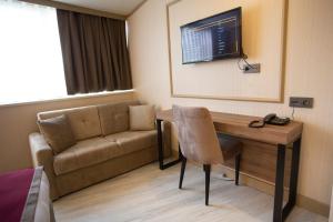 a living room with a couch and a table and a television at Beşiktaş Serenity Hotel in Istanbul