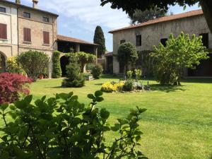 an old building and a yard with green grass at DIMORA DESENZANI - Lago di Garda in Esenta