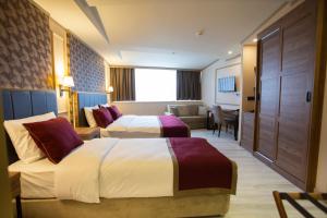 ein Hotelzimmer mit 2 Betten und einem Sofa in der Unterkunft Beşiktaş Serenity Hotel in Istanbul