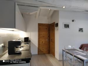 Habitación con cocina con mesa y puerta. en Un oeil sur la cathédrale, en Aosta