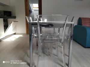 Una mesa de cristal y sillas en una habitación. en Un oeil sur la cathédrale, en Aosta