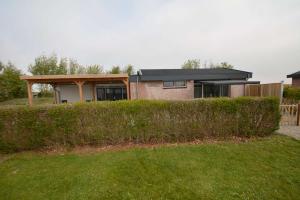 a house on a hill with a hedge in front of it at Lamsoor in Serooskerke