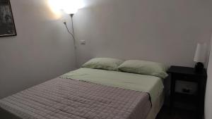 małą sypialnię z łóżkiem z oświetleniem w obiekcie Zaccheo 9 w mieście Pitigliano