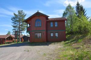 a red house with a clock on the side of it at Sjumilskogen in Trysil