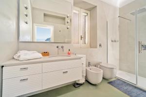 Baño blanco con lavabo y aseo en Villa Hibiscus, en Capri