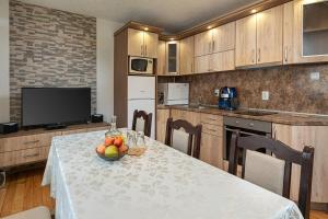 a kitchen with a table with a bowl of fruit on it at Villa Samodiva in Yagodina