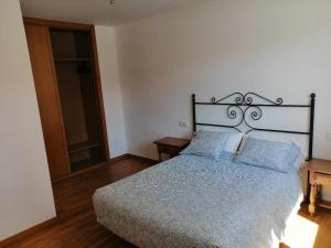 1 dormitorio con 1 cama grande con almohadas azules en Apartamentos MonteBlanco Costa da Morte, en Neaño