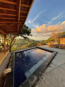 a swimming pool in front of a house at Elang Hillside Bamboo Villas in Labuan Bajo