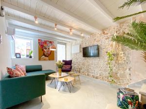 a living room with a couch and a tv on a stone wall at Izmir House in Chania