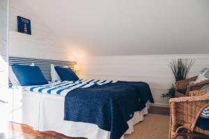 Schlafzimmer mit einem Bett mit blauer und weißer Bettwäsche in der Unterkunft Skatans Café & Krog in Skatan