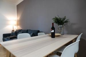 a bottle of wine sitting on a table in a living room at Flow Apartments Kirchsteig in Merano +22 photos