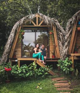 mężczyzna i kobieta siedzący w domku na drzewie w obiekcie Bodhi Santa Catalina w mieście Santa Catalina