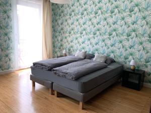 a bed in a bedroom with a green wall at MAMA'S APPART in Epping-Urbach