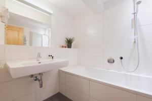 a white bathroom with a sink and a shower at Hotel Gabl by Alpeffect Hotels in Sankt Anton am Arlberg +42 photos