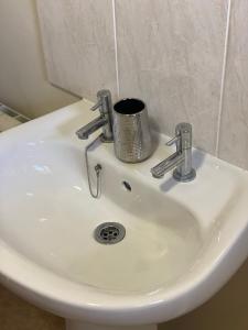 a white sink with two faucets on it at Ellers Farm Cottage in Carnforth