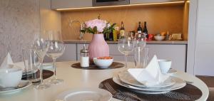 a table with glasses and plates and a vase with flowers at Apartment Holata 201 in Hradec Králové