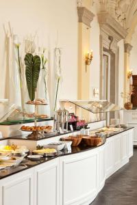 uma linha de buffet com muitos pratos de comida em Althoff Grandhotel Schloss Bensberg em Bergisch Gladbach