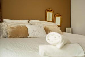 1 dormitorio con 2 camas, sábanas blancas y espejos en ÁTICO CONFORT ORIO Parking incluido, en Orio